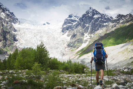 徒步旅行在山上。登山者带着旅游背包去了布满积雪的洛基山。休闲活动。爬山。在高加索山上徒步旅行的人
