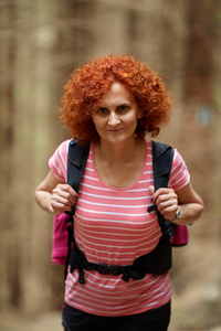 在山上徒步旅行的卷发红发女人