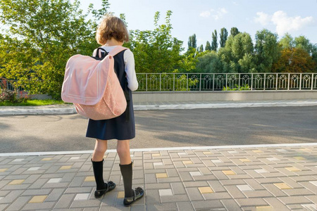 户外画像的一个小学生, 女孩用眼镜, 制服与背包。学校, 教育, 知识和儿童。后视图, 复制空间