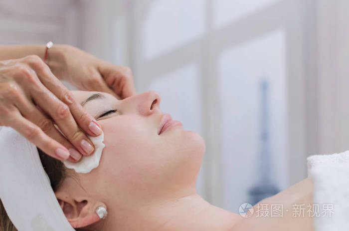 年轻美丽的妇女接受面部清洁和水疗治疗