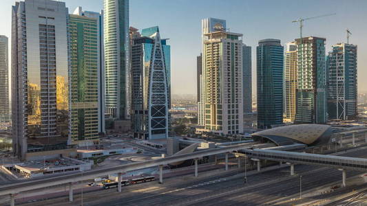 在日出时, timelapse 的空中观景塔摩天大楼, 扎耶德路和地铁线上的交通。从迪拜码头的屋顶景观与晨灯