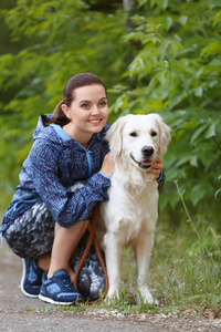 一个年轻的女人和她的狗一起在公园里。宠物护理