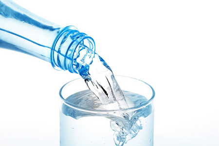 水从瓶子里倒进白色背景上的玻璃