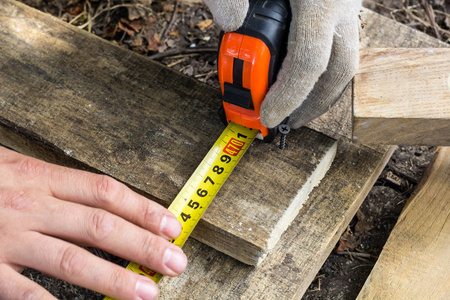 男子手测量在建筑工地上的赌木板