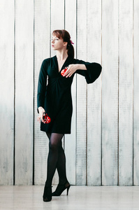 一个穿着黑色连衣裙的年轻跳舞的女孩, 红色的响板, 轻 b