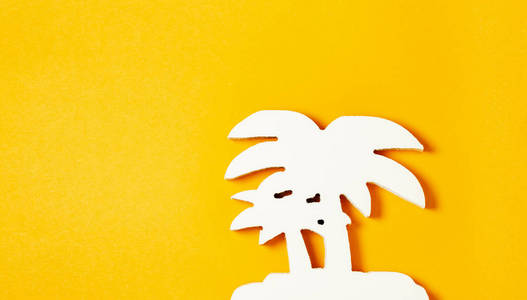 白色棕榈树由树在柔和的橙色背景。平躺。夏季热带概念
