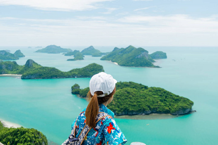 年轻的亚洲妇女旅行者与背包看查看在 Angthong, 泰国 Moo 岛