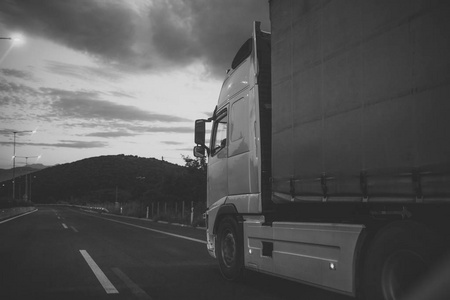 载重汽车, 面包车在傍晚的路上行驶, 后面的景色。kamion 车, 卡车, 运输货物或物品在国家之间。国际运输理念