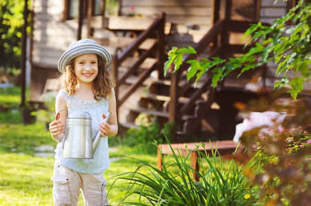 快乐的孩子在帽子里玩小园丁, 并帮助在暑假浇花