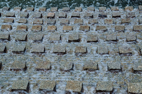 背景与喷泉元素的特写与水小河快速地跑通过列规则形状的方形的石头