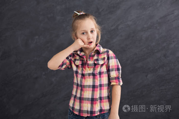 灰色背景下的小女孩愁眉苦脸