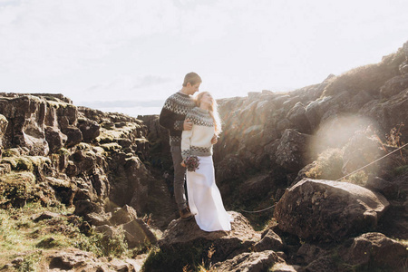 年轻夫妇穿着针织毛衣拥抱山顶