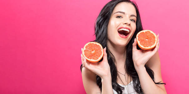 幸福的年轻女人控股橘子