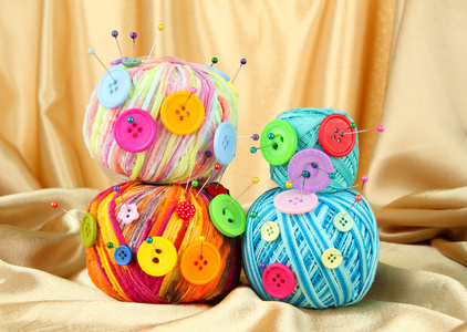 多彩按钮和多色毛球，彩色织物背景上