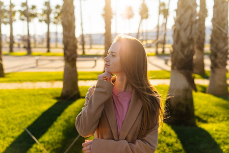 年轻的女孩对夕阳和手掌构成