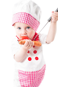 宝贝女儿做饭戴厨师帽与蔬菜和泛上的健康食品和童年白 background.the 概念隔离