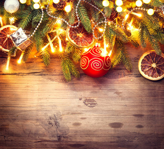 装饰圣诞树的灯光, 球和橙片的木制背景