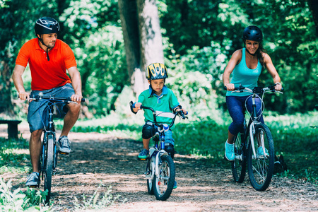 开朗的家庭在公园里骑自行车