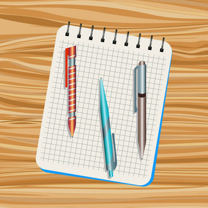 笔记本 橙色笔 蓝色的钢笔和棕色的笔