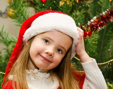 礼物的圣诞老人帽子的小女孩过圣诞节