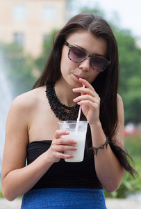 十几岁的女孩与一杯奶昔上夏季的一天