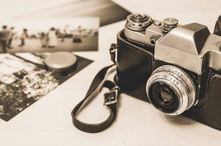 老式的照片相机在棕色复古皮革外壳持有人在木背景与 instagram 复古滤镜效果