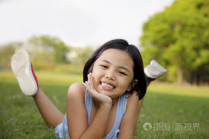 亚洲小女孩放松,在公园里笑的很开心