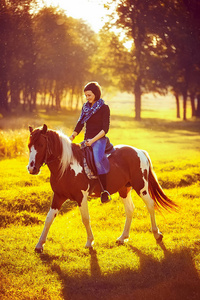 美丽的女孩骑着马在农村