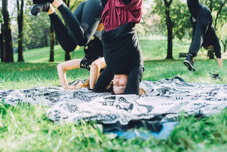 两名年轻女子运动员伸展户外做瑜伽