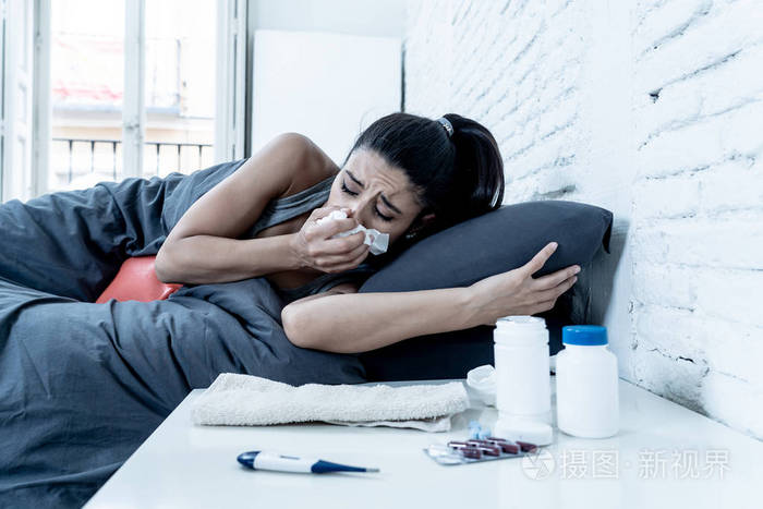 生病的有吸引力的女人躺在床上感觉不适与头痛疼痛鼻子高温感觉疲劳和