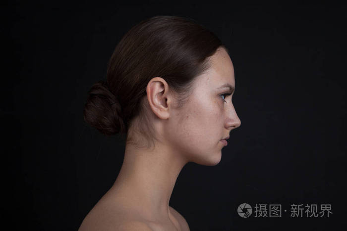 黑色背景下没有化妆的女人脸的轮廓照片-正版商用图片
