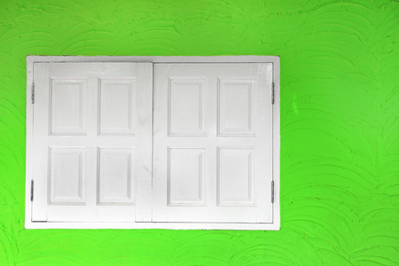 绿墙上的白色木制窗口