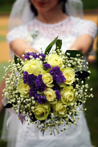 新娘拿着一束结婚花束在她的手在自然