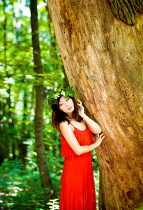 美丽的女孩在森林中的红色礼服