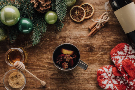 在木桌上, 圣诞节概念的热葡萄酒和冬季手套杯的高视图