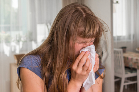 生病的妇人与流感或冷打喷嚏到手帕