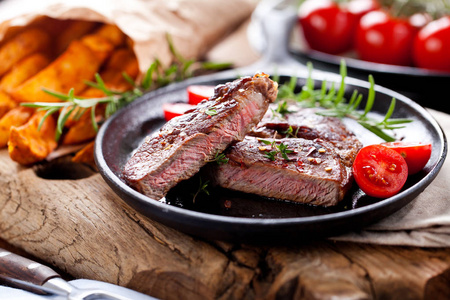 中度稀有烤牛肉, 土豆黑石背景。顶部视图, 平躺