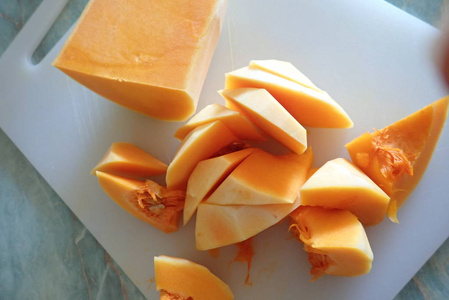 一个橙色的南瓜切成碎片的细节在厨房