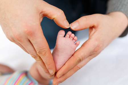 父亲或母亲抱着刚出生的婴儿的脚