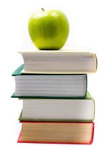 在上面在白色背景上的书堆和绿苹果