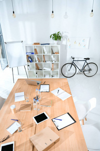 空办公室内部与桌和自行车反对墙壁的看法