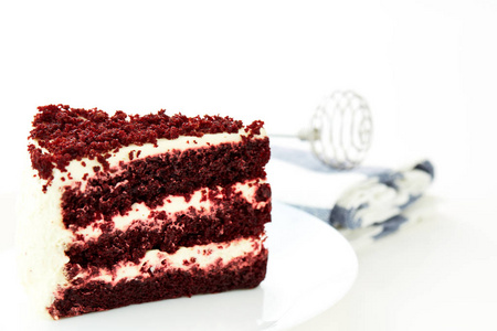 在白色背景上切一个红色天鹅绒蛋糕的勺子