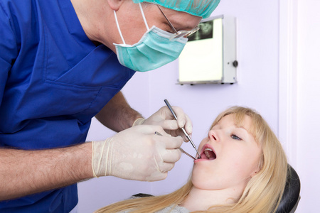 检查一个女人的牙齿的牙外科医生