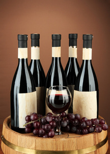 葡萄酒瓶 眼镜和酿酒葡萄，木桶，棕色背景上的组成