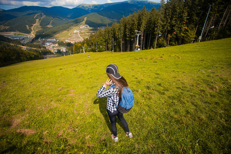 后视图的徒步旅行妇女与背包在山顶上。旅游理念