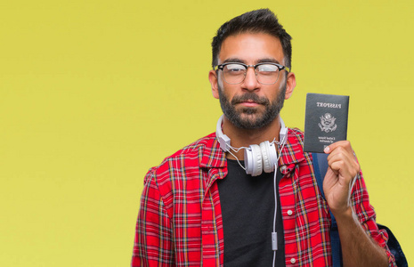 成人西班牙裔学生男子持有美国护照在孤立的背景和自信的表情, 聪明的面孔认真思考