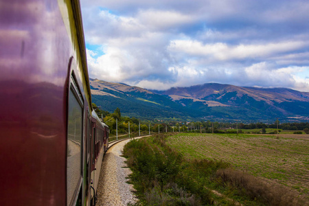 一座山的风景, 一个美丽的天空, 白云和绿草, 在火车上拍照。火车旅行, 浪漫的火车旅行