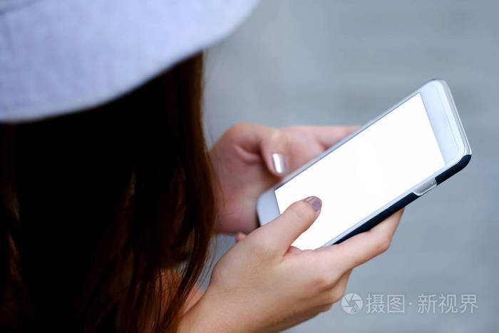 女人正在玩智能手机白色显示器.特写镜头从后面