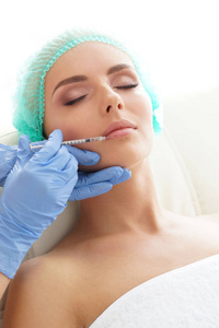 医生在一个年轻女人美丽的脸上注射。整形外科皮肤提升与美容医学理念