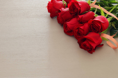 情人节浪漫背景与美丽的花束玫瑰在木桌上